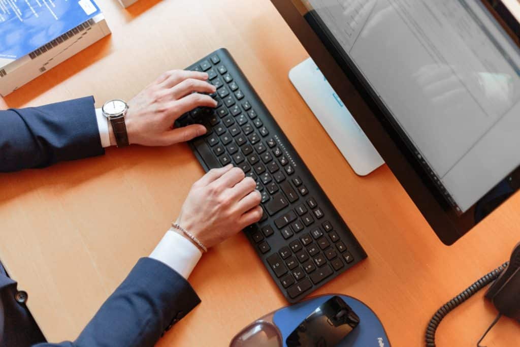 A person typing on a computer keyboard.