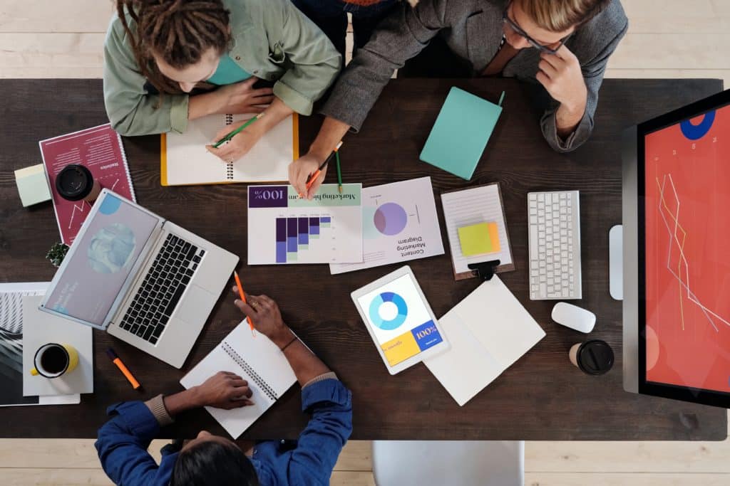 Top down view of IT managers reviewing KPI reports